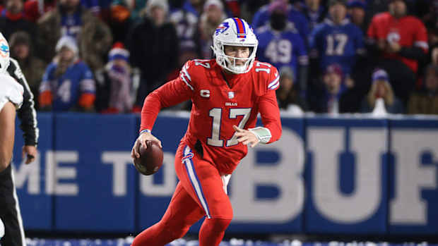 Bills quarterback Josh Allen rolls to his left as he looks downfield.